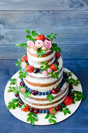 Naked wedding cake decorated with berries and flowersの写真素材