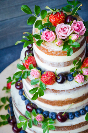 Naked wedding cake decorated with berries and flowersの写真素材