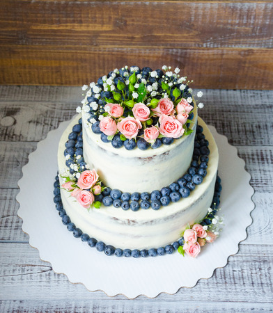 Gentle wedding cake with blueberry and rosesの写真素材