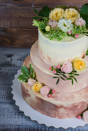 three-tiered wedding ombre cake decorated with roses and greeneryの写真素材
