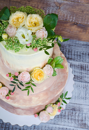 three-tiered wedding ombre cake decorated with roses and greeneryの写真素材