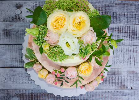 three-tiered wedding ombre cake decorated with roses and greeneryの写真素材