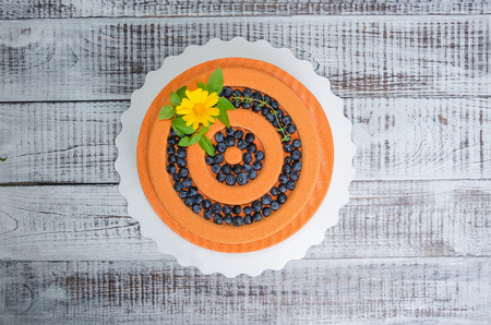 orange chocolate velour cake with flowers, blueberries and basilの写真素材