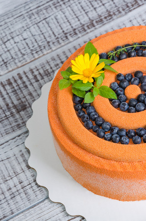 orange chocolate velour cake with flowers, blueberries and basilの写真素材