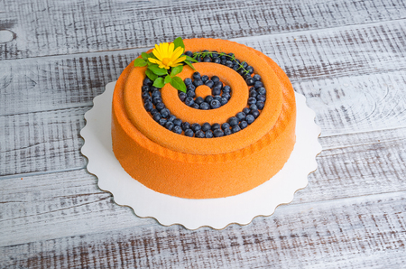 orange chocolate velour cake with flowers, blueberries and basilの写真素材