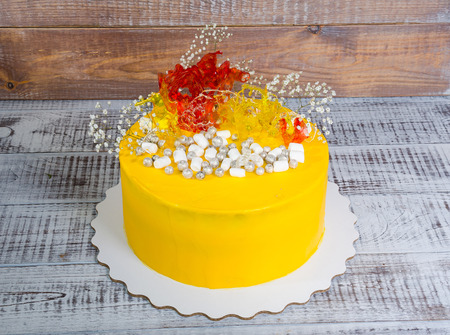 yellow cream cheese cake with caramel decoration and gypsophilaの写真素材