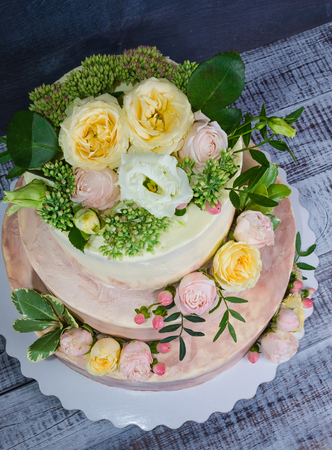 three-tiered wedding ombre cake decorated with roses and greeneryの写真素材