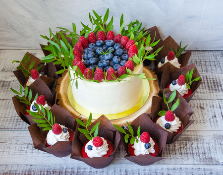 a berry wedding cake and red velvet cupcakesの写真素材