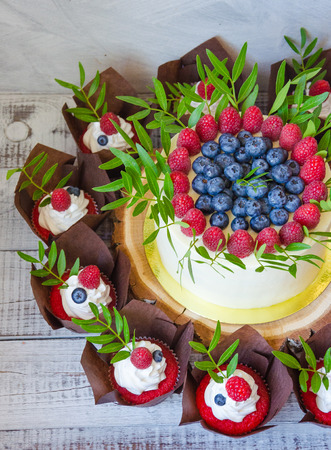 a berry wedding cake and red velvet cupcakesの写真素材