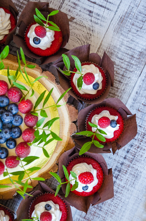 a berry wedding cake and red velvet cupcakesの写真素材