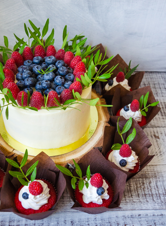 a berry wedding cake and red velvet cupcakesの写真素材