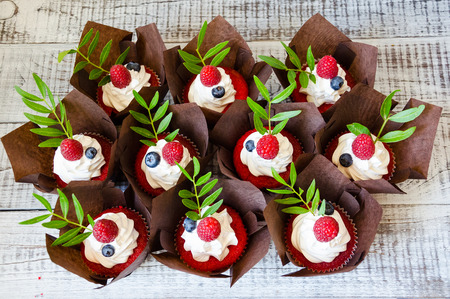 a berry wedding cake and red velvet cupcakesの写真素材