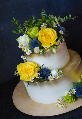 Two layered gilded wedding cake with flowersの写真素材