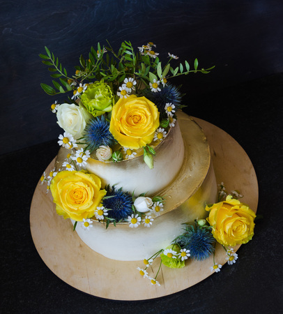 Two layered gilded wedding cake with flowersの写真素材