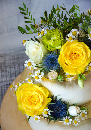 Two layered gilded wedding cake with flowersの写真素材