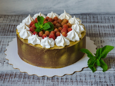 gilded chocolate cake with merengues, raspberries and mint leavesの写真素材