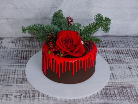 New year color drip chocolate cake with red roses and fur treeの写真素材
