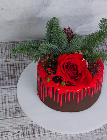 New year color drip chocolate cake with red roses and fur treeの写真素材