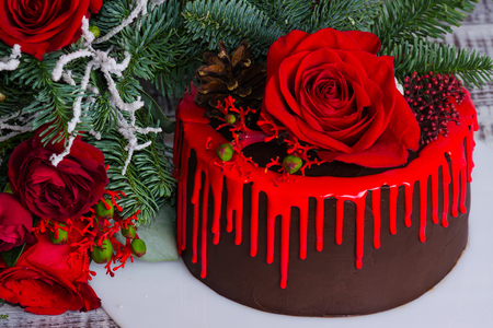 New year color drip chocolate cake with red roses and fur treeの写真素材