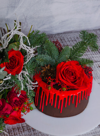 New year color drip chocolate cake with red roses and fur treeの写真素材