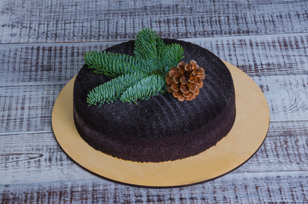 Christmas chocolate velvet cake decorated with pinecone on woodの写真素材