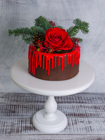 New year color drip chocolate cake with red roses and fur treeの写真素材