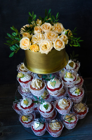 a Gentle wedding cake in golden chocolate box with yellow roses and pistachioの写真素材