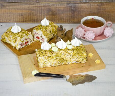 Pistachio merengue vanilla roll with strawberry confi on wooden plateの写真素材