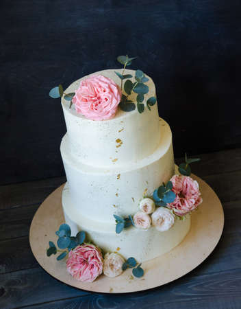 three tiered wedding cream cheese cake with roses and eucalyptusの写真素材
