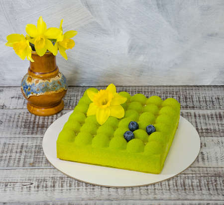Square Chocolate velvet cake with daffodil and blueberriesの写真素材
