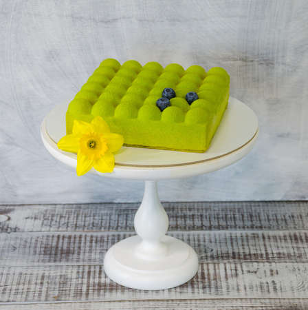 Square Chocolate velvet cake with daffodil and blueberriesの写真素材