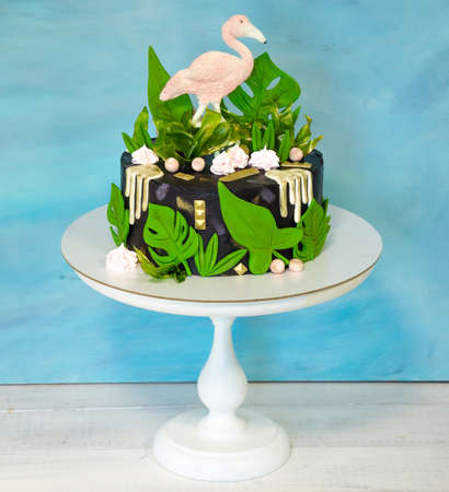 A black creamchease cake with flamingo and tropical leavesの写真素材