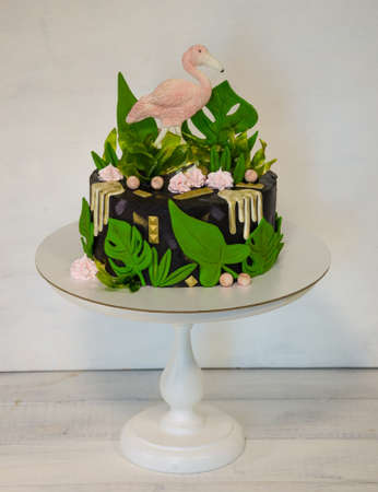 A black creamchease cake with flamingo and tropical leavesの写真素材