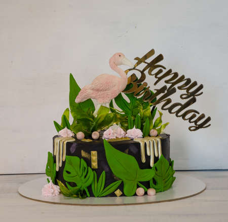 A black creamchease cake with flamingo and tropical leavesの写真素材