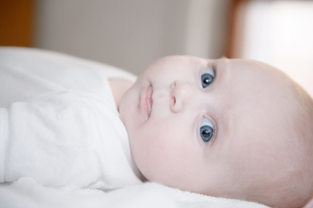 Baby girl posing with bright eyes, baby is newborn and very littleの写真素材