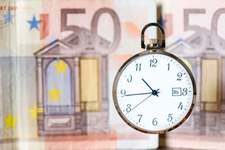 pocket watch with euro banknotes and coins, still lifeの写真素材
