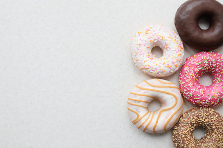 Five donut glaze on a light background. Left space for your design.の写真素材