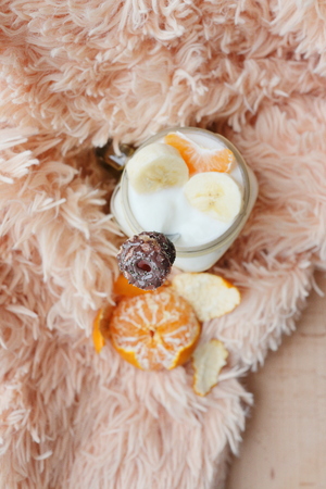 Yogurt with banana and tangerine on a light soft background. View from above. Photo is suitable for illumination of the healthy lifestyle and diet, comfort.の写真素材