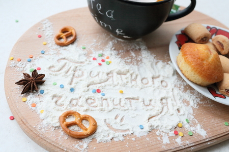 Tea still life with an inscription in Russian. Mug with plate of sweets, and the inscription on the sahornoy powder.の写真素材