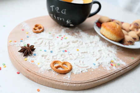 Tea still life with an inscription in Russian. Mug with plate of sweets, and the inscription on the sahornoy powder.の写真素材