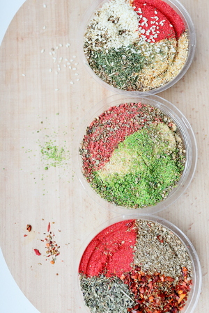 Three jar with mix of spices on a cutting board on a white background. Jars are arranged in a row, the middle vertical composition.の写真素材