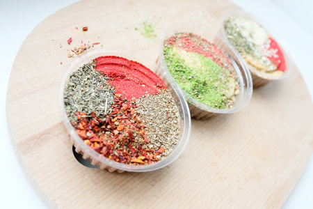 Three jars with a mix of oriental spices on a light background. The focus of one jar, the rest are blurred. Is suitable for the cooking and articles of oriental spices.の写真素材