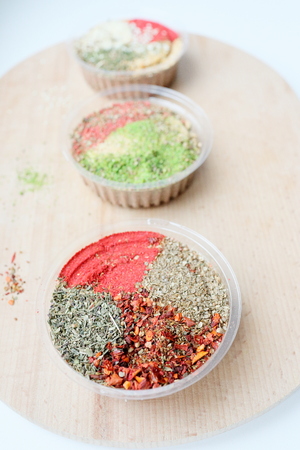 Three jars with a mix of oriental spices on a light background. The focus of one jar, the rest are blurred. Is suitable for the cooking and articles of oriental spices.の写真素材