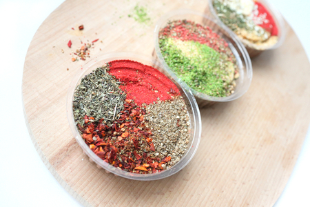 Three jars with a mix of oriental spices on a light background. The focus of one jar, the rest are blurred. Is suitable for the cooking and articles of oriental spices.の写真素材