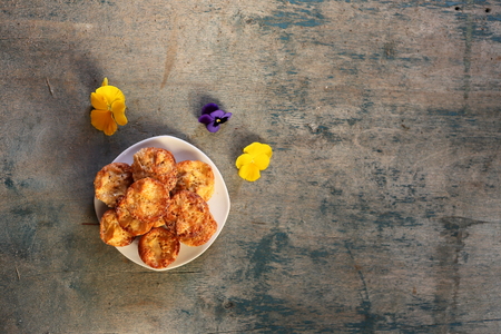 Plate with mafins on a wooden blue background with flowers. On the right is space for design. Homemade baking.の写真素材