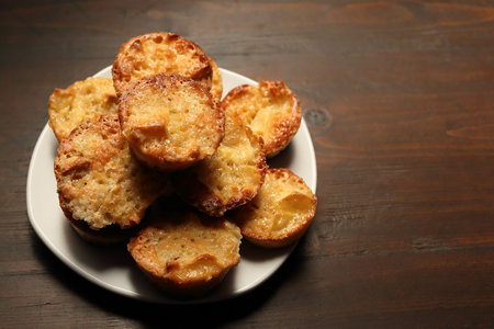 Plate with muffins on a wooden old background. Beautiful pastries. Place for design on the right.の写真素材