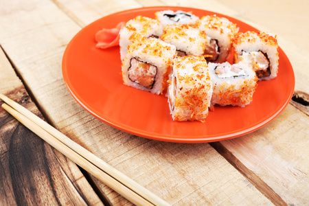 Beautiful picture of Japanese food. Sushi on an orange plate, on a wooden background and chopsticks.の写真素材