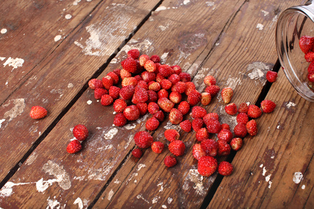 Strawberries scattered on a wooden background. Copyspace on the left.の写真素材