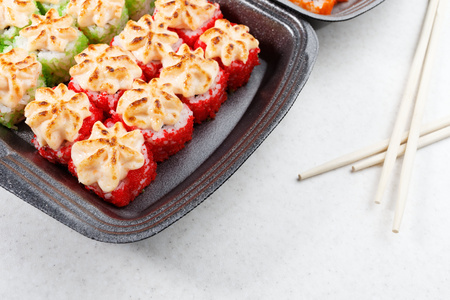 Sushi in plastic packaging. Baked sushi and chopsticks.の写真素材