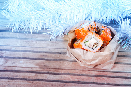 Christmas sushi. Sushi under the Christmas tree, in gift wrapping.の写真素材